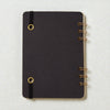 Back cover of spiral-bound cocktail recipe journal with black book board and brass wire binding