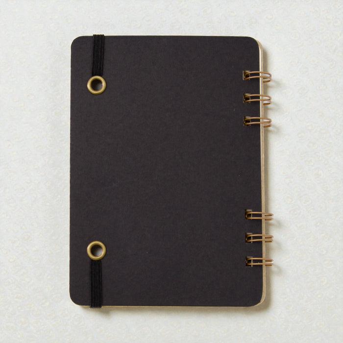 Back cover of spiral-bound cocktail recipe journal with black book board and brass wire binding