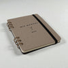 Spiral-bound cocktail recipe journal with chipboard cover and black elastic band closure
